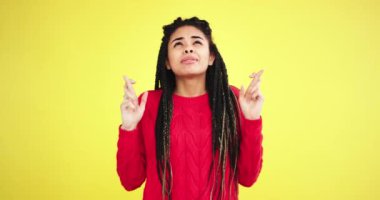 Sarı arka plan karizmatik komik Afrika lady çok etnik bir stüdyoda çapraz parmak ve bir şey için dua sonra mutlu o almak istediği ve çok komik bir dreadlocks ile gülümseyen