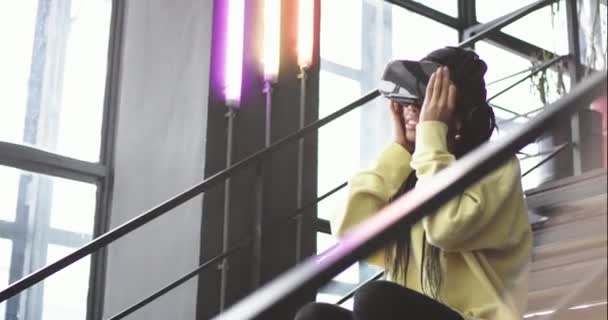 Bureau moderne multi ethnique dame avec de longs dreadlocks en utilisant une VR pour la première fois profiter du temps, explorer les jeux — Video