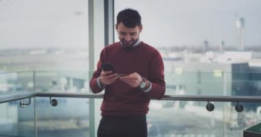 Mutlu ofis çalışanı modern bir binada smartphone ve banka kartını kullanma online banka hesabını kontrol, sonunda o mutlu ve heyecanlı. 4k. yavaş hareketleri