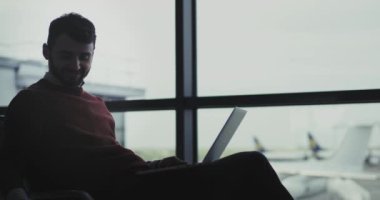 Closeup işadamı için onun biniş beklerken havaalanında o onun laptop üzerinde çalışıyor ve onun konuşan, o büyük bir ruh var.
