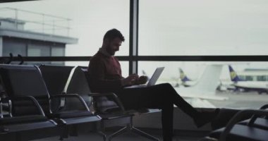 Onun uçuş yatılı için bekleyen o kadar da banka kartı formu bazı transferler yapmak onun defteri kullanarak Havaalanı işadamı bekleme salonunda içinde.