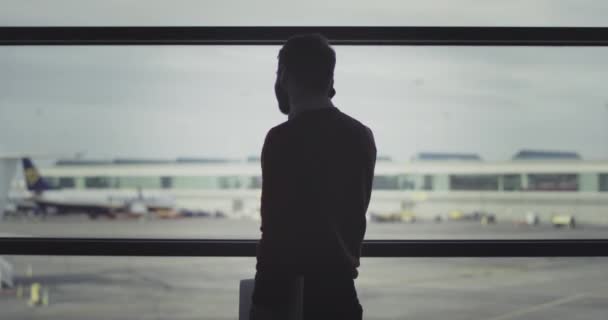 Man spreken op zijn telefoon in de luchthaven van wachtruimte, zeer gelukkig hij wacht op zijn vlucht te krijgen aan boord — Stockvideo