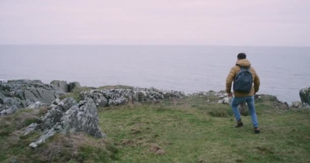 Felice turista arrivato in un posto incredibile in cima alle scogliere di Moher in Irlanda, ammira tutto il paesaggio intorno . — Video Stock