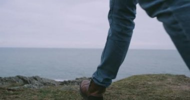 Closeup ayrıntıları dağ shore top kahverengi bot giyen bir adam turist okyanus manzarası hayranım o.