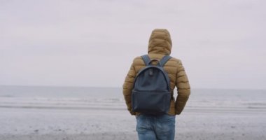 Kamera önünde deniz görünümü şaşırtıcı deniz kıyısı mavi bir çanta için arkasında, bir büyük plaj adam üzerinde