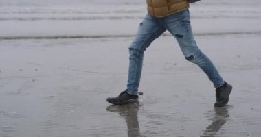 Islak kumsalda, çalışan adam closeup ıslak kum sahil, o su üzerinden yürüyüş ve mutlu, duygu closeup Ayrıntılar yanında