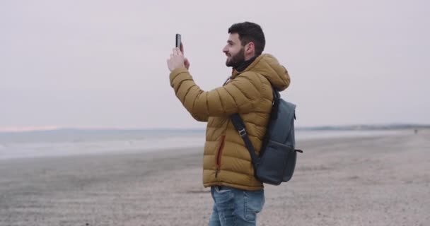 Joven viajando por el increíble país de Irlanda llegó a un hermoso lugar en la gran playa y hermosa vista al mar tomar fotos del paisaje — Vídeos de Stock