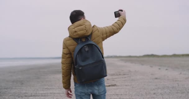 Increíble lugar en la gran playa con una vista al mar hombre turístico tomar fotos del paisaje con su teléfono — Vídeos de Stock