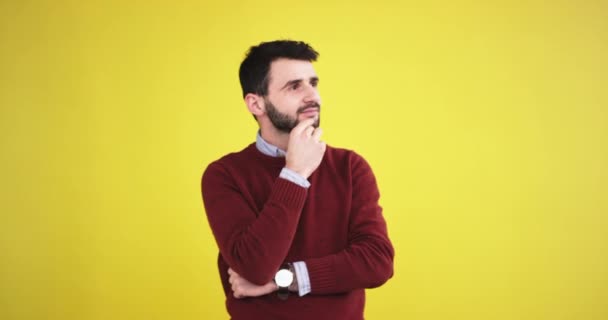 Homem pensador no estúdio com uma parede de fundo amarelo depois que ele encontrou uma solução e feliz olhando diretamente para a câmera. tiro no épico vermelho. movimentos lentos. 4k — Vídeo de Stock