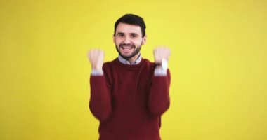 Kamera mutlu ve heyecanlı bir sarı arka plan duvar ile stüdyoda istediği bir şey aldı eliyle gesticulating önünde büyük delikanlı gülümseyen.