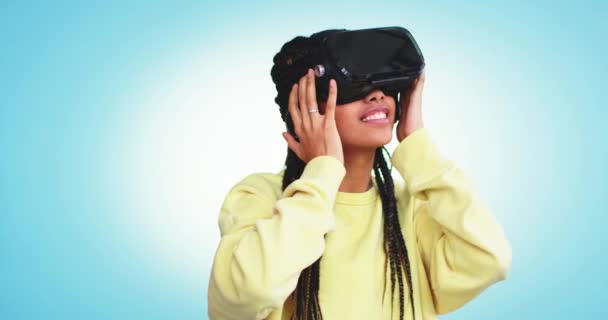 Она использует очки виртуальной реальности, чтобы хорошо провести время и почувствовать себя счастливой в студии с синей фоновой стеной — стоковое видео