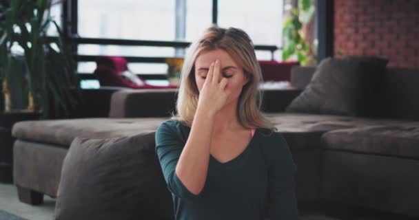 Atractiva mujer rubia primer plano en una ropa deportiva tienen la meditación concentrada mientras se sienta en el suelo en la sala de estar de diseño rústico moderno, por la mañana pasó un tiempo para su cuerpo y alma . — Vídeo de stock