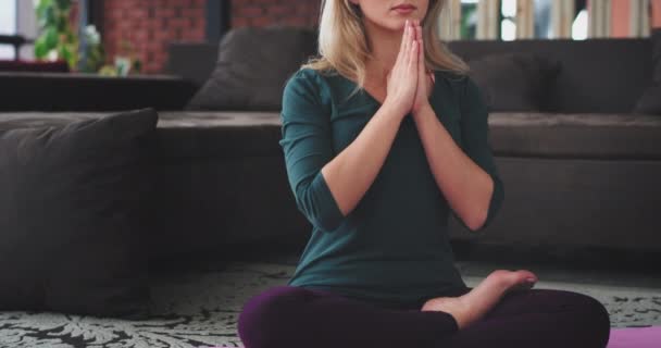 Details van een vrouw die het beoefenen van yoga in de ochtend thuis in de woonkamer, ze hebben een meditatie vormt om energie voor de hele dag, ze zittend op de vloer op een tapijt. — Stockvideo