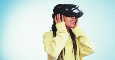 Bir Studio ile a birden parlamak arkadaki mavi arka plan duvar ile aynı anda oynamak için bir sanal gerçeklik gözlükle büyük Afrika güzel bayan ve dacing gülümseyen