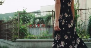 Genç Bayan yaz rüzgarlı gün, sokakta yürürken uzun romantik bir elbiseyle.