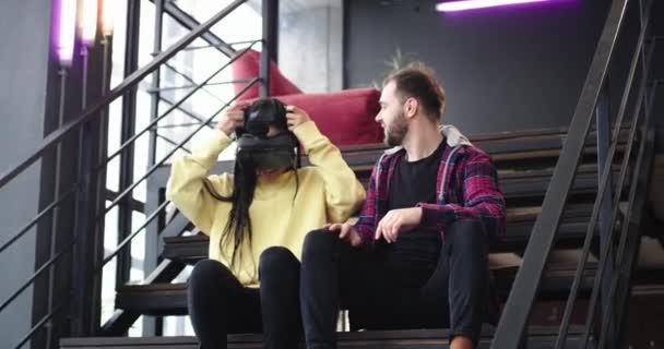 В современном офисе один человек с бородой и его коллега по офису во время перерыва играют в очки виртуальной реальности, они взволнованы — стоковое видео