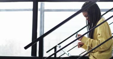 Karizmatik genç Afrika Bayan onun kredi kartı ve defter, o office salonda oturmuş kullanarak bir çevrimiçi işlem yapmak