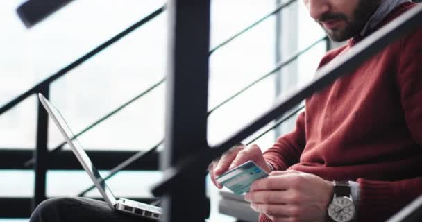 Details Nahaufnahme eines Bürokauffrau, die eine Online-Bestellung über die Kreditkarte und mit dem Notizbuch für die Transaktion Mann sitzt auf der modernen Bürotreppe. 4k — Stockvideo