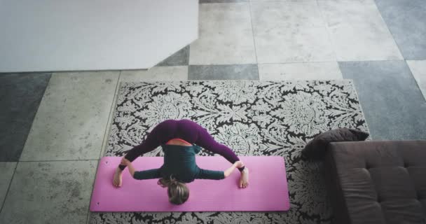 Estirar el cuerpo en la señora de la mañana practicando yoga en la estera de yoga rosa en la sala de estar en casa, tomando video de la parte superior superior en el increíble loft de diseño urbano . — Vídeo de stock