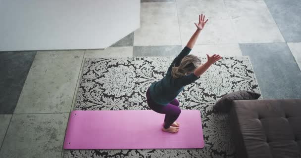 Yoga posa en la señora de la mañana practicando para sí misma en casa en la sala de estar consigue un cuerpo elástico, vistiendo ropa deportiva cómoda capturando vídeo desde la parte superior superior. 4k — Vídeos de Stock