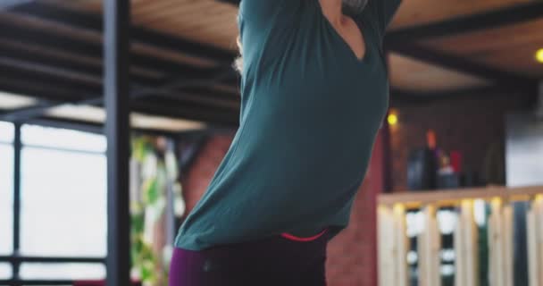 Detaljer damen bär en bekväma sportkläder hon öva yoga övningar på morgonen hemma i vardagsrummet med modern design interiör — Stockvideo
