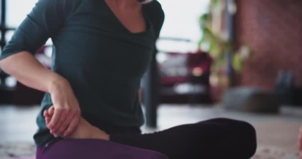 Деталі дама практикує вправи з йоги вранці вона розтягує тіло і робить важкі пози йоги вранці вдома в сучасному дизайні горища — стокове відео