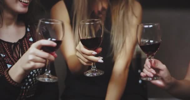 Celebrando o tempo três mulheres fecham-se bebendo vinhos tintos e saúde todos juntos na festa . — Vídeo de Stock