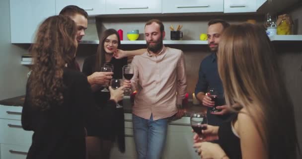 Charismatische multi-ethnische Gruppe junger Leute haben eine Party, bei der sie miteinander plaudern und gemeinsam die Gläser heben und jubeln. 4k — Stockvideo