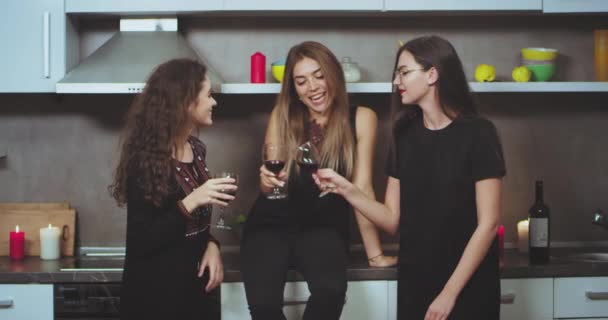 Hermosas señoras carismáticas bebiendo vino en la cocina y tener una buena conversación entre sí. 4k — Vídeo de stock