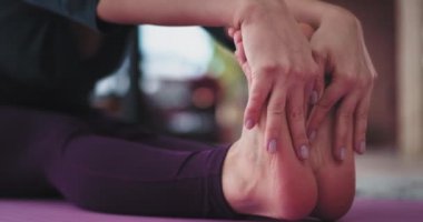 Evde yoga uygulamak, spor mat, o rahat sportswea giyen vücut germe sarışın bir genç kadın portresi. 4k