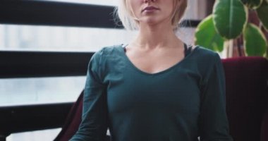 Ev tatlı bayan yoga meditasyon var kırmızı kanepede pozlar o kapalı göz ve daha fazla enerji almak için yoğun bir yüz. 4k