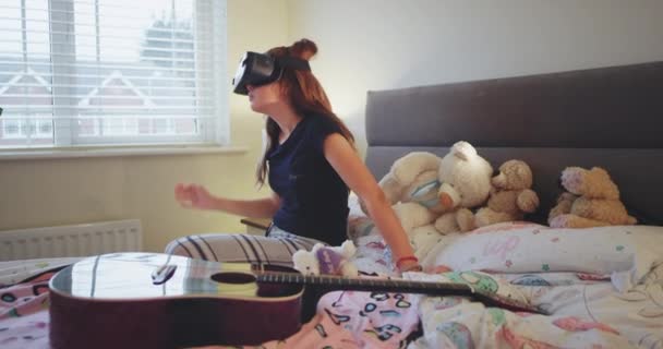 Teenager Mädchen im Pyjama, in ihrem Schlafzimmer die Erforschung einer neuen Erfindung einer Virtual-Reality-Brille, sie sind sehr beeindruckt mit der vr. Zeitlupe — Stockvideo