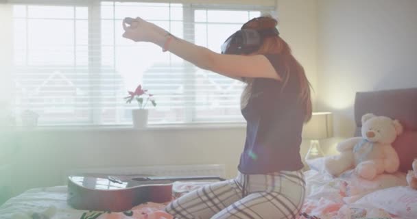 Velmi nadšený mladá dáma v posteli pohodlné hraní s Vr a velmi koncentrované ona zkoumá virtuálního herního světa. — Stock video