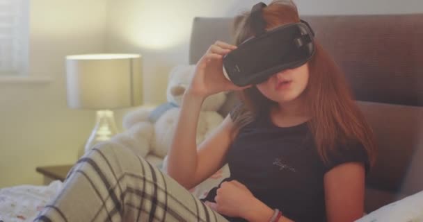 Närbild dam med en virtual reality-glasögon att utforska världen på hennes sovrum i en pyjamas glad hon använder en ny teknik, och njuter av — Stockvideo