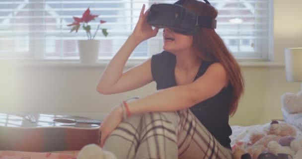 Харизматичная симпатичная девушка-подросток в своей спальне исследует виртуальный мир с помощью нового изобретения виртуальной реальности в технологии — стоковое видео