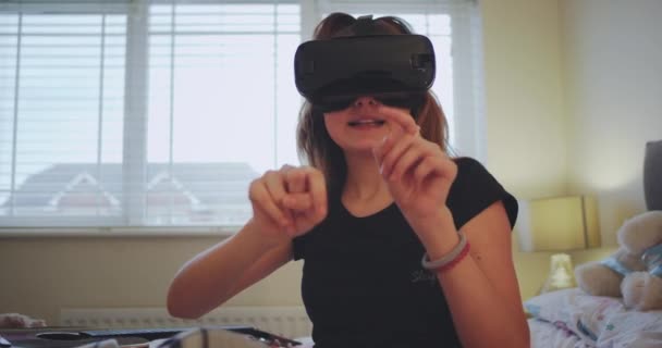 Detalles de una adolescente con un juego virtual usando una VR en su habitación acostada en la cama y pasando un rato divertido. 4k — Vídeo de stock