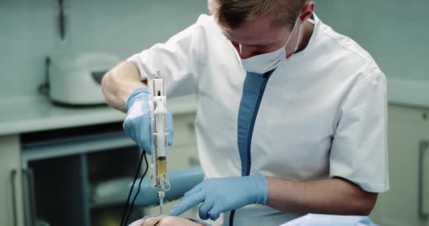 Portrait d'un homme médecin faire une nouvelle procédure de vampirefacial ou prp, nouvelle technologie femme mature patient faire une procédure de micro-aiguille . — Video