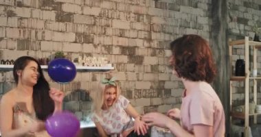 Bir çatı katı yatak odası bayanlar pijama partisi var eğlenceli yastıklar ve büyük gülümseyen balon ile onlar şirin pijama giymiş dayak zaman.