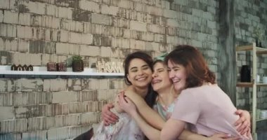 Doğal çekici genç bayanlar çok etnik birbirimizi mutlu ve gülümseyerek kamera önünde büyük tutan pijama yatakta sabahı