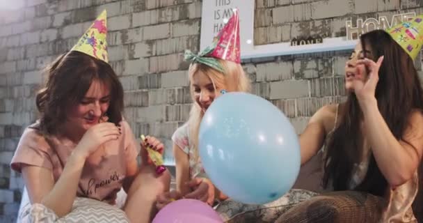 Le attraenti signore multietniche che celebrano una festa di compleanno a casa in una camera da letto moderna hanno un pigiama party utilizzando i palloncini e il cappello di compleanno per creare un'atmosfera di compleanno. 4k — Video Stock