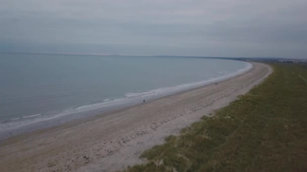 Erstaunliche Meerblick mit großem Strand und schönen grünen Feld, Menschen, die durch den Strand laufen und Videos aus der Luft mit einer Drohne aufnehmen. — Stockvideo