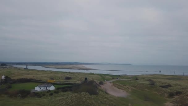 Erstaunliche Landschaft Drohne Aufnahme Video von einem grünen Feld Blick und Meerseite, mit einer Jacht herumfahren auf dem Wasser. — Stockvideo