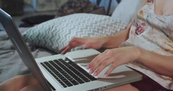 Δακτυλογράφηση κυρία στο σημειωματάριο με πιτζάμες, ξαπλώ στο κρεβάτι και δουλεύοντας πριν πάω για ύπνο — Αρχείο Βίντεο