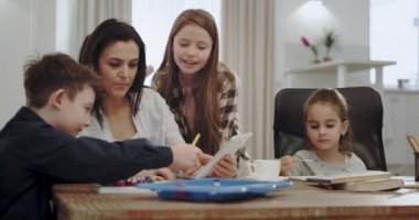 Çok güzel olgun anne, modern bir oturma odasında birlikte oynayan çocukları ile dostça bir zaman harcama büyük mutlu gülümseyen. 4k