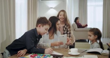 Mutlu ve gülümseyen Anne onlar doğru sonuçlar mutlu birbirlerine sarılmak olsun sonunda bir sorun çözmek için bir tablet kullanarak bir okul projesinde çocuklara yardım. 4k
