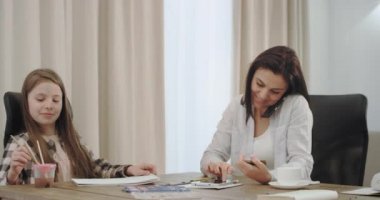 İş kadını evden çalışan, telefonda konuşurken bir şey sipariş etmek için bir kredi kartı kullanarak, ve modern bir ev tasarımı onu üç çocuk ile ödev yapıyor.