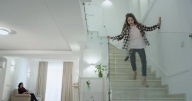 Sabahları karizmatik iki küçük çocuk okula gitmeden önce anne ve küçük kız kardeşi sarılmak için ilk kata aşağı gitmek.