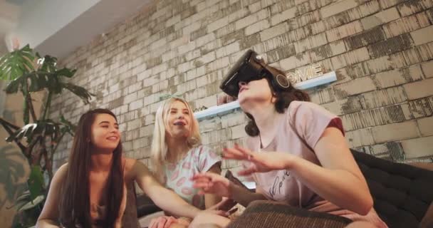 Привлекательные юные леди, наслаждаясь временем вместе они исследуют новые технологии очки виртуальной реальности, одна из них путешествовала виртуально по миру пугаются. 4k — стоковое видео