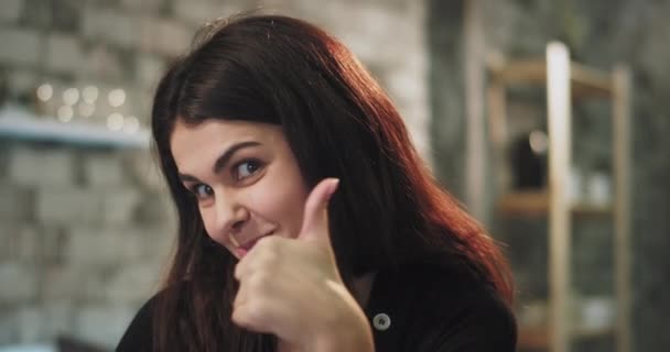 Glimlachende dame goed uitziende met een keramische beugel op zoek rechtstreeks naar de camera en gebaren met de handen erg mooi — Stockvideo