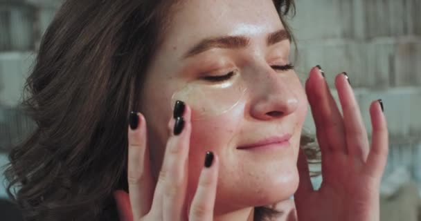 Une bonne Dame regardant avec la beauté de sensation de speckle tout en faisant un masque d’yeux le matin, elle ont une routine de beauté — Video